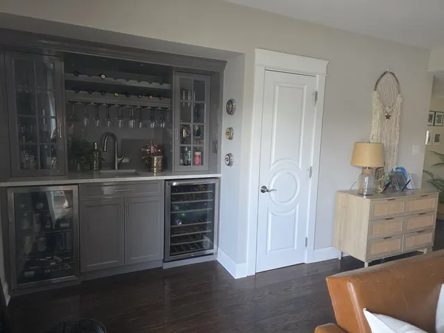 an empty room with wooden floor cabinet and window