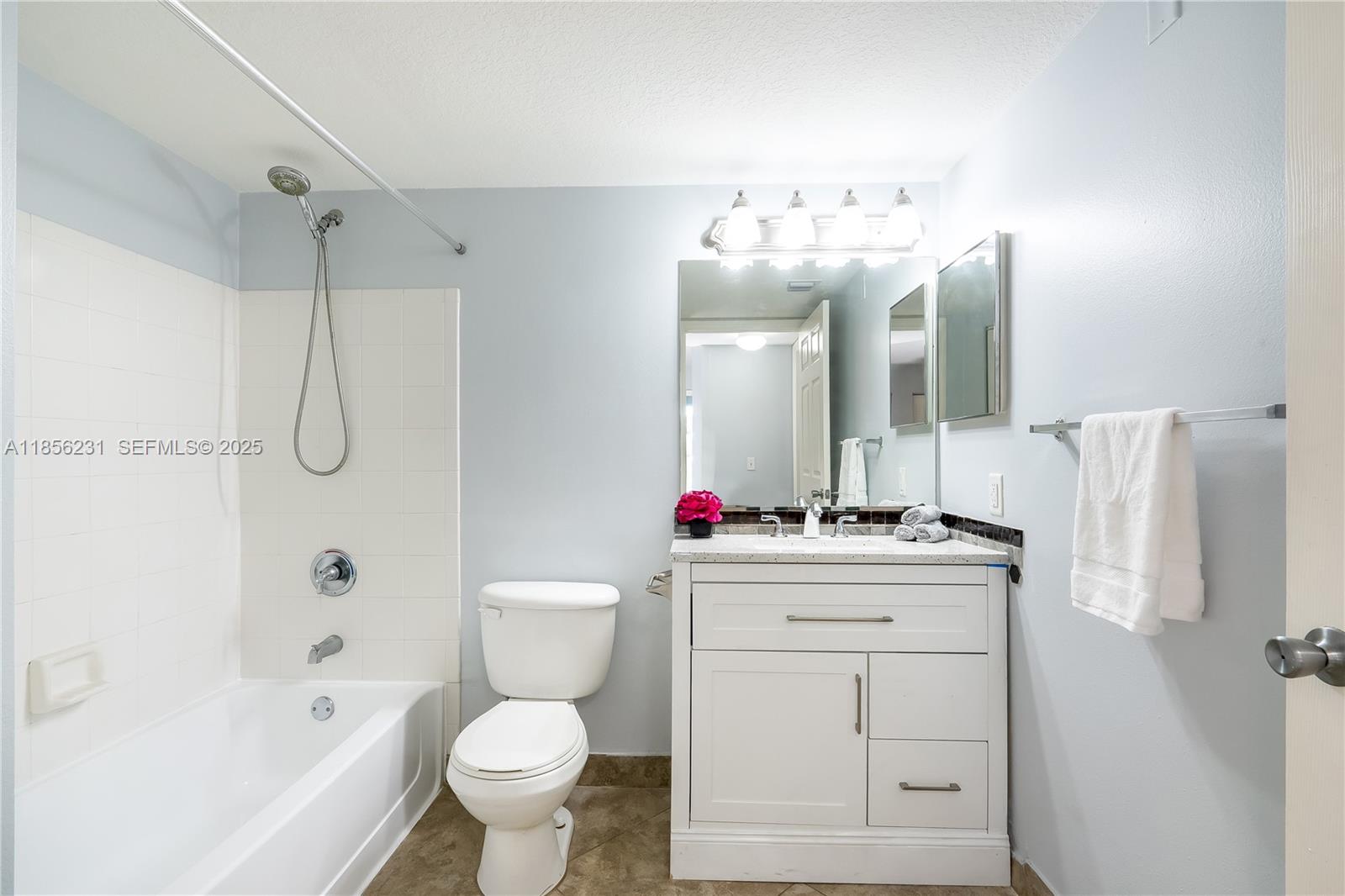 1308 Villa Circle, Unit 1308 Boynton Beach, FL 33435 - Photo 21 of 35 a bathroom with a sink vanity mirror bathtub and toilet