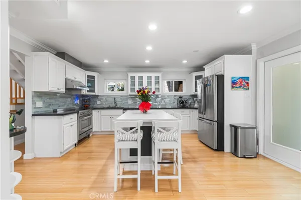 a kitchen with stainless steel appliances granite countertop a refrigerator and a stove top oven