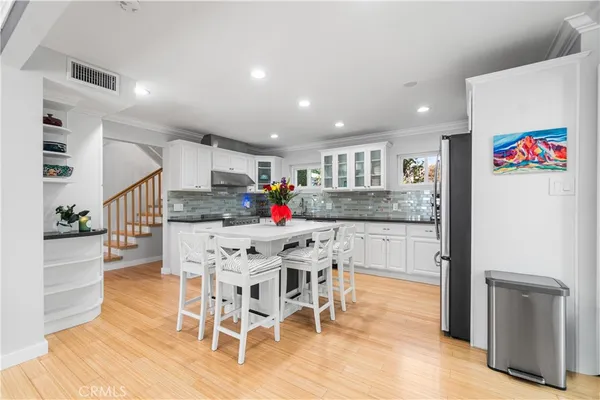 a kitchen with stainless steel appliances granite countertop a refrigerator and a stove top oven