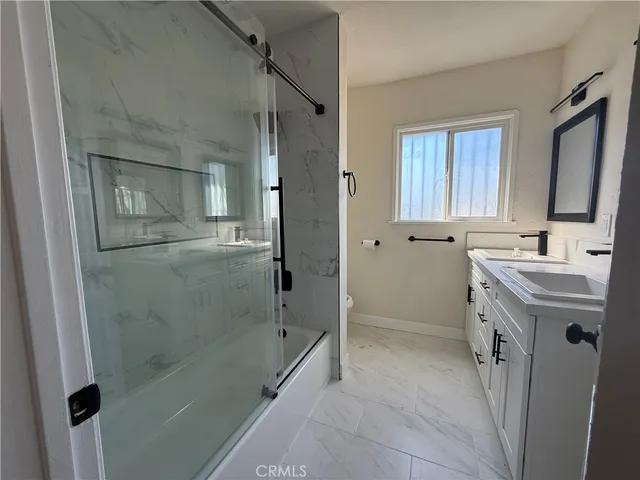 a bathroom with a shower sink vanity and mirror