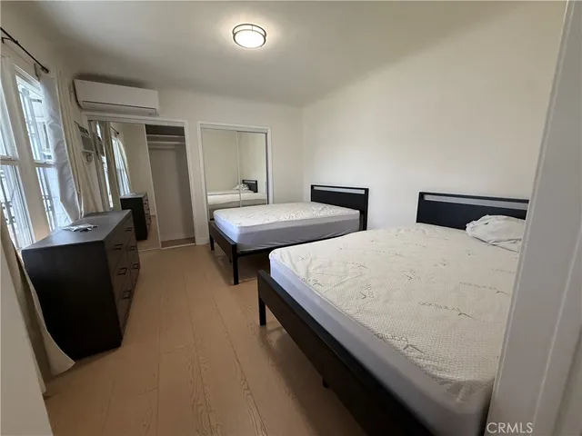 a room with two bed and a mirror