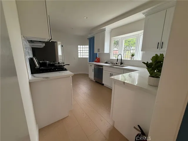 a kitchen with a sink a counter top space and a stove top oven