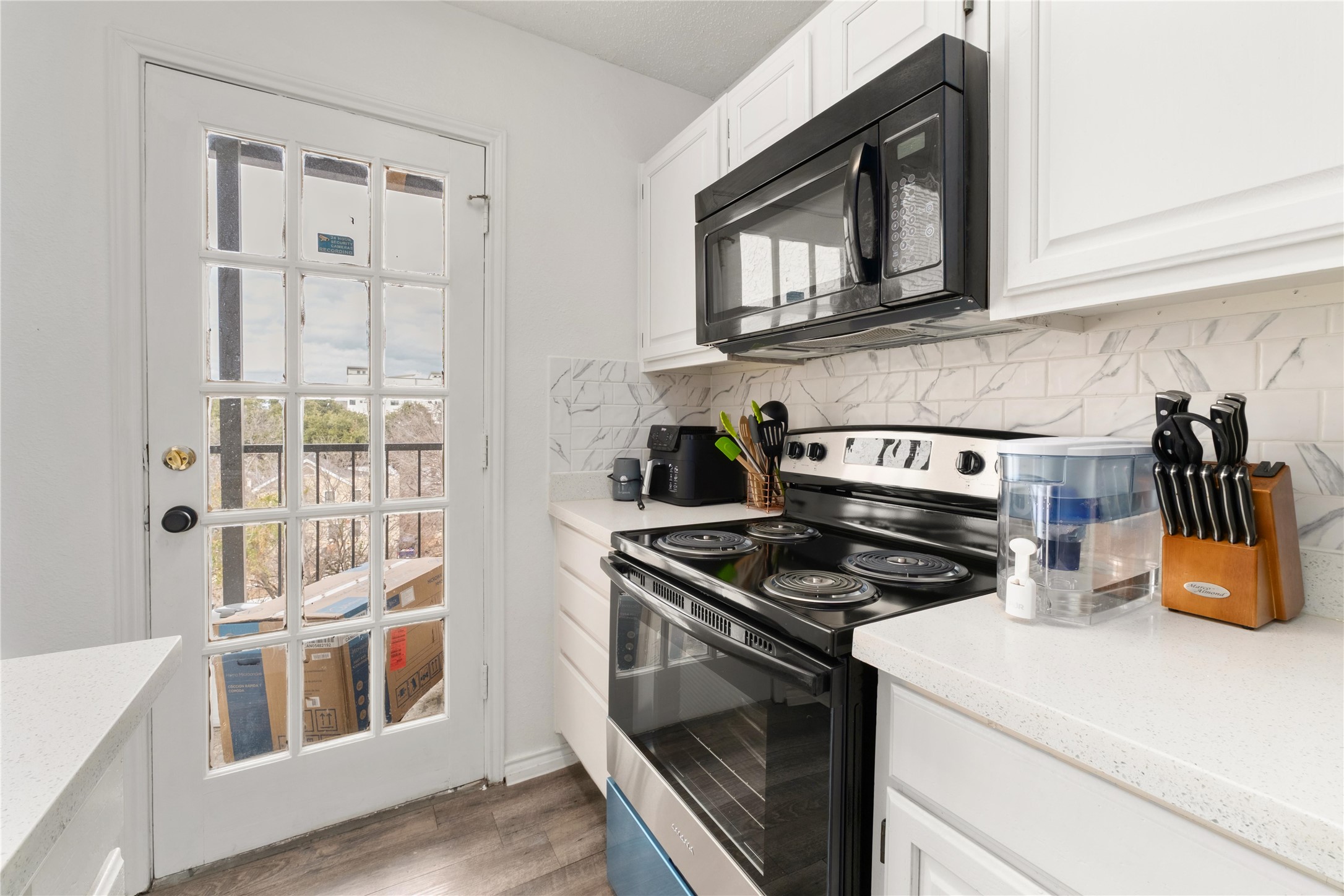 2409 Leon Street, Unit 307 Austin, TX 78705 - Photo 11 of 23 a kitchen with stainless steel appliances granite countertop a stove and a microwave