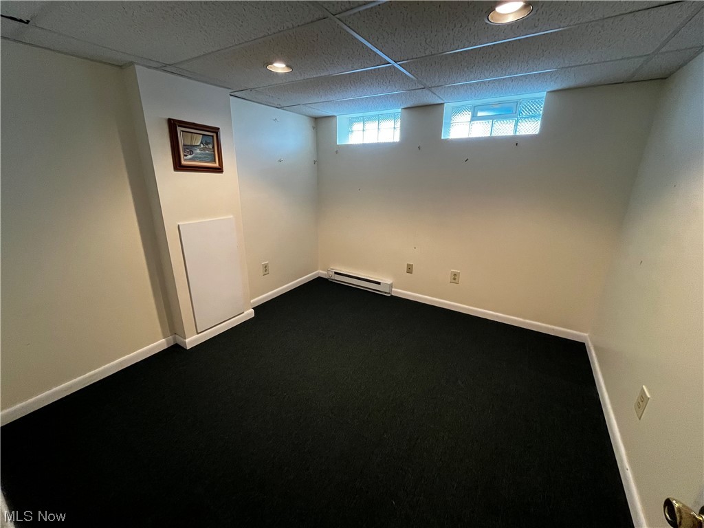 30824 Clarmont Road Willowick, OH 44095 - Photo 22 of 24 Basement featuring dark carpet, a baseboard heating unit, and a drop ceiling