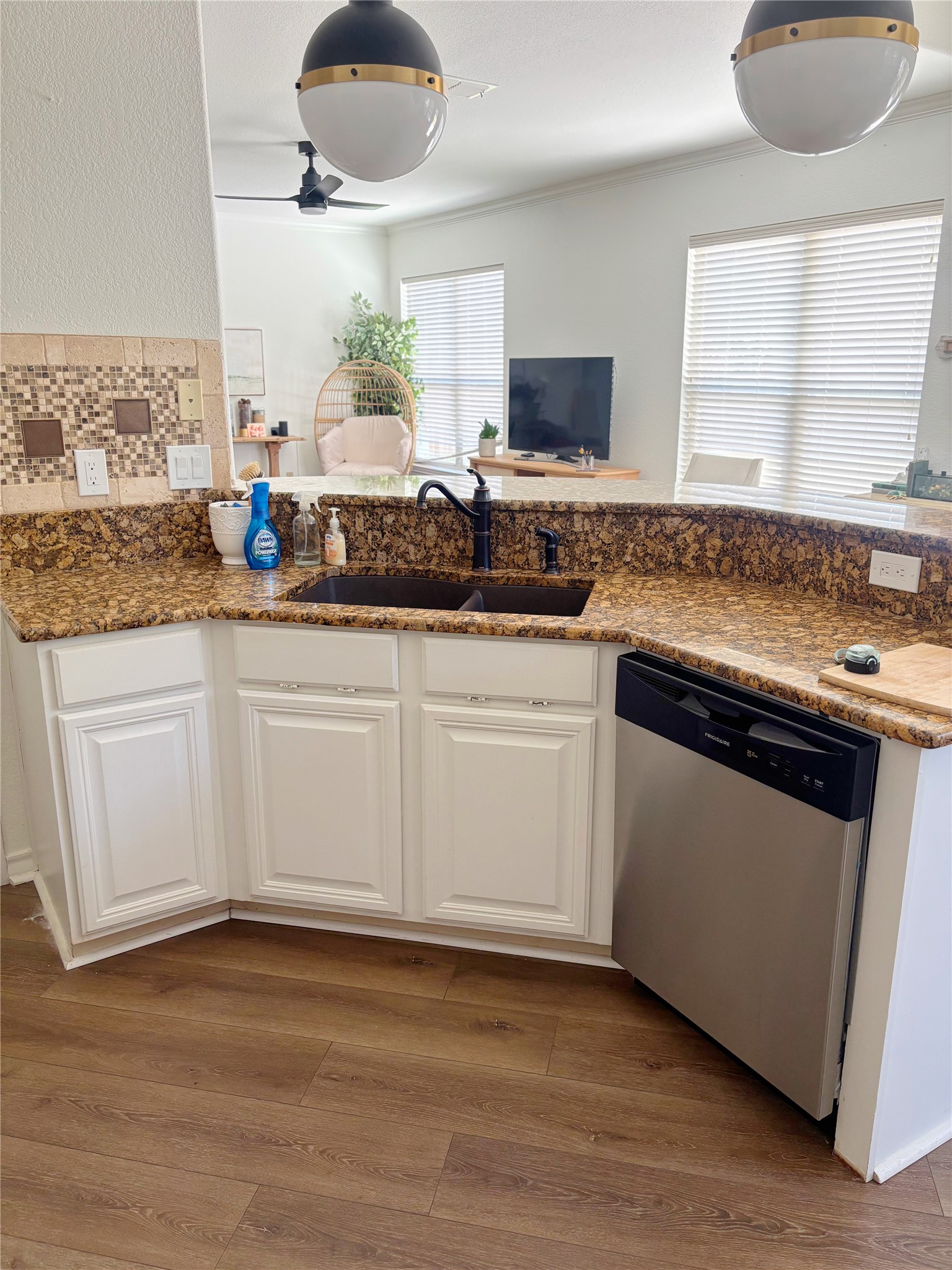 3336 Ashleys Way Marion, TX 78124 - Photo 6 of 15 Kitchen with white cabinets, stainless steel dishwasher, light wood-style flooring, tasteful backsplash, and pendant lighting