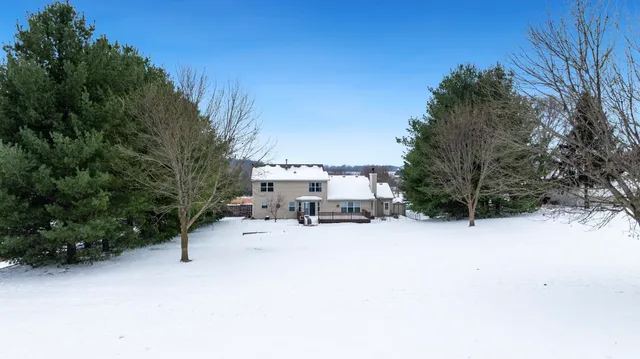 a view of a house with a yard covered in snow