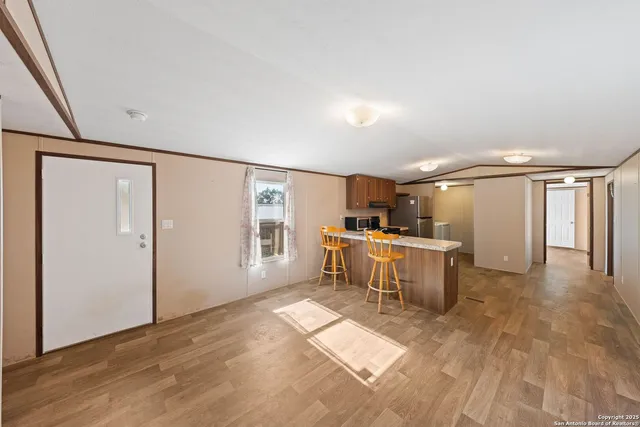 a view of a kitchen with a sink and dishwasher with wooden floor