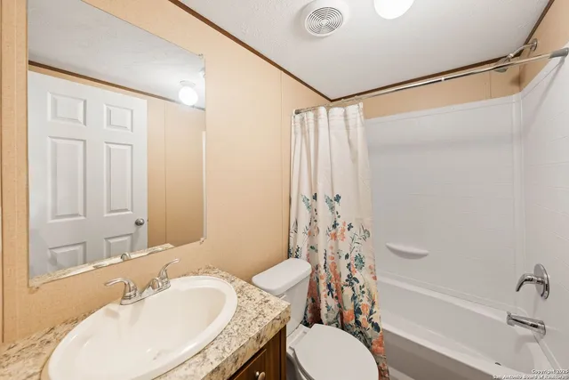 a bathroom with a granite countertop sink toilet and shower