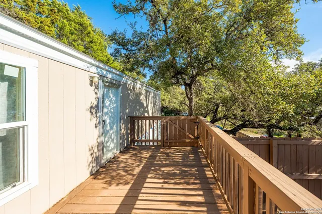 a view of a balcony with wooden floor and fence