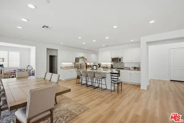 a living room with stainless steel appliances kitchen island granite countertop furniture and wooden floor
