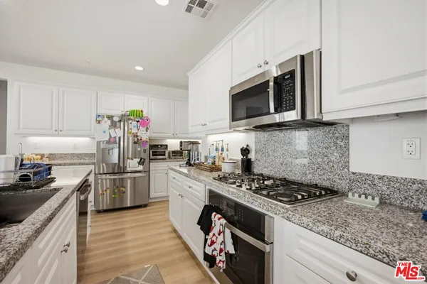 a kitchen with stainless steel appliances granite countertop a stove a sink dishwasher and a microwave