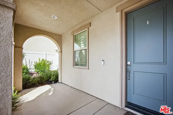 a view of a room that has a large window and front door