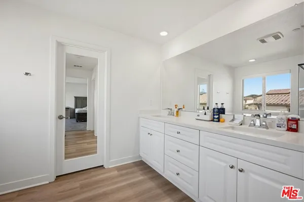 a walk in closet with clothes and shoes