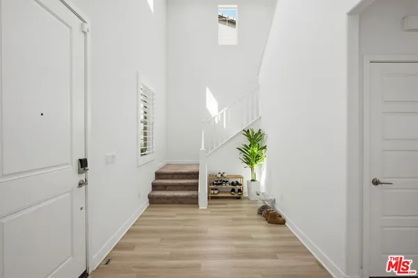 a view of a hallway with wooden floor and stairs
