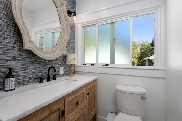 a bathroom with a double vanity sink mirror and a toilet
