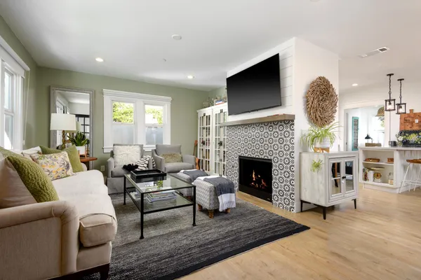 a living room with furniture a fireplace and a flat screen tv