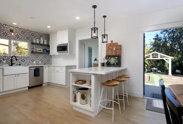a kitchen with stainless steel appliances kitchen island a stove a table and chairs in it