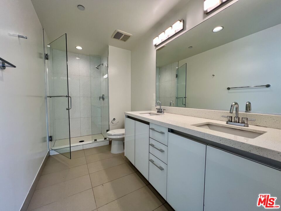 11715 Bellagio Road, Unit 204 Los Angeles, CA 90049 - Photo 8 of 27 a bathroom with a double sink shower and a mirror