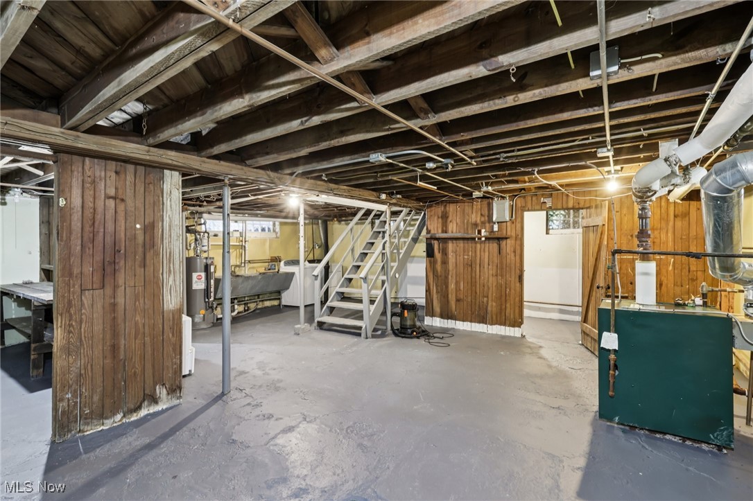 3054 East Overlook Road Cleveland, OH 44118 - Photo 40 of 50 Basement with stairs, wood walls, a heating unit, washer / dryer, and gas water heater