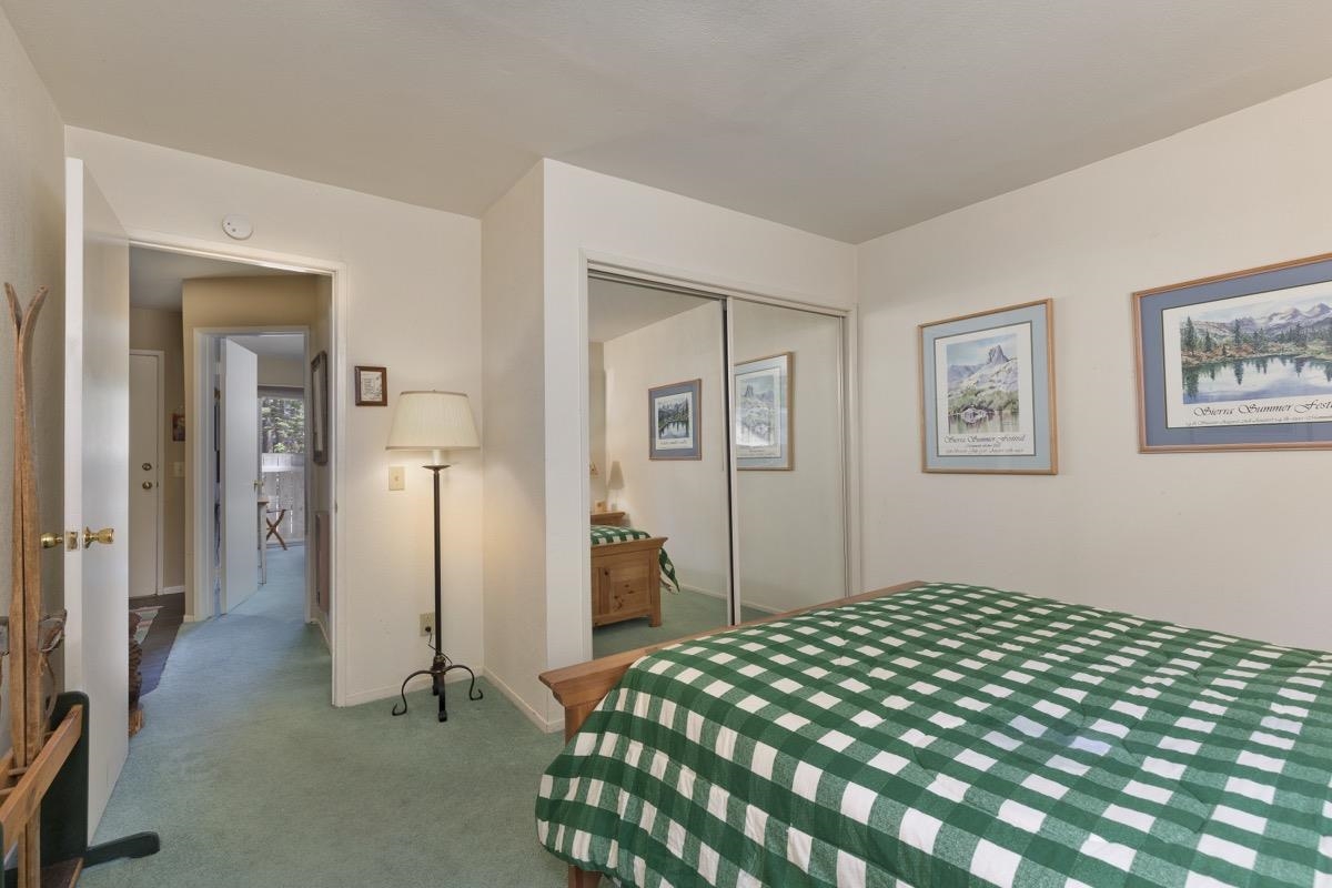 44 Tyrol Lane, Unit 209 Mammoth Lakes, CA 93546 - Photo 20 of 31 a bedroom with a large bed and a chandelier