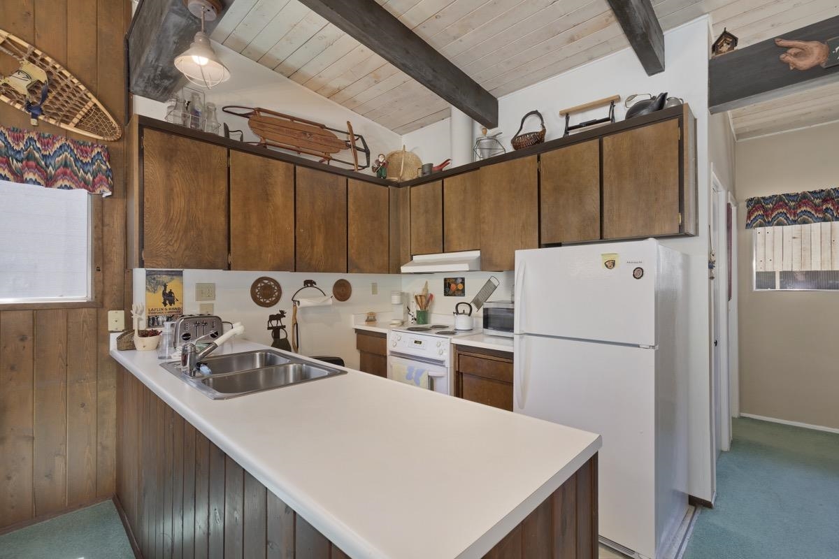 44 Tyrol Lane, Unit 209 Mammoth Lakes, CA 93546 - Photo 10 of 31 a kitchen with refrigerator and white cabinets