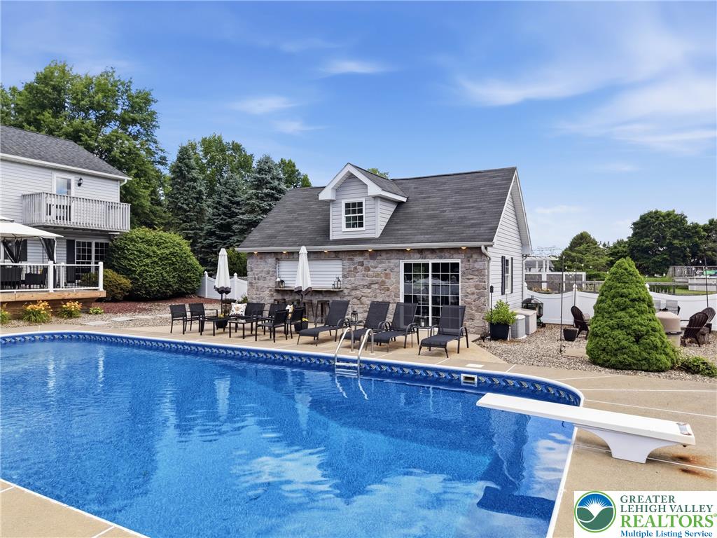 890 Lahr Road Nazareth, PA 18064 - Photo 45 of 71 An inviting backyard oasis awaits with a sparkling blue pool and a charming pool house.