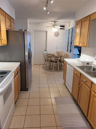 a kitchen with a sink a refrigerator and chairs