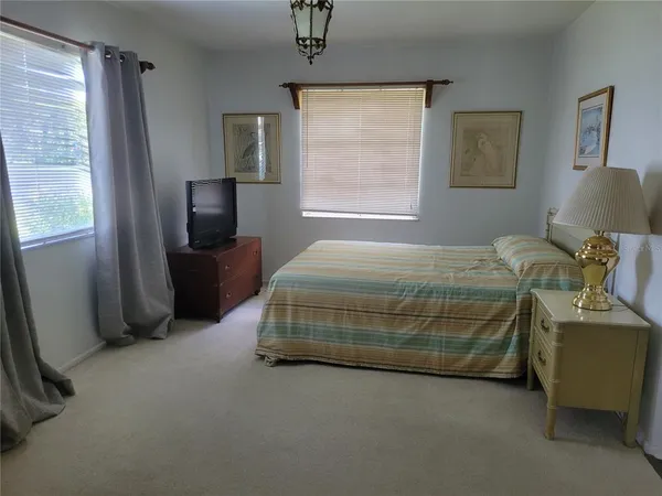 a bedroom with a bed and a tv on table