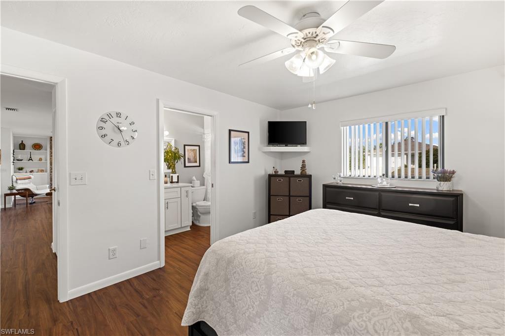 18517 Sebring Road Fort Myers, FL 33967 - Photo 17 of 32 a bedroom with a large bed and a chandelier