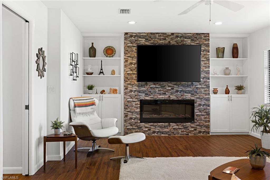 18517 Sebring Road Fort Myers, FL 33967 - Photo 10 of 32 a living room with furniture a flat screen tv and a fireplace