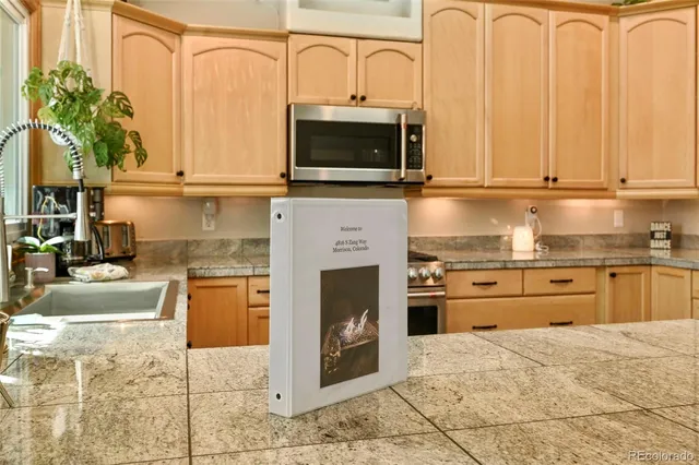 a kitchen with stainless steel appliances granite countertop a stove a sink and a microwave