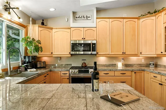 a kitchen with stainless steel appliances a stove sink and cabinets