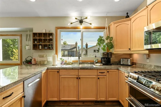 a kitchen with granite countertop a sink and a stove top oven