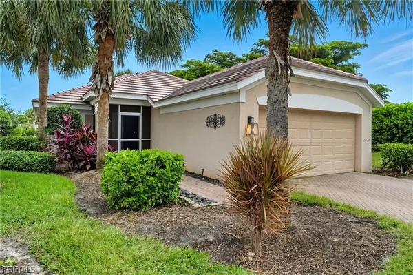a view of a house with a small yard and palm trees