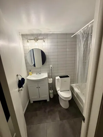 a bathroom with a toilet sink and mirror
