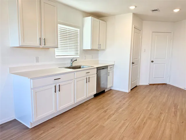 a kitchen with wooden floors and appliances