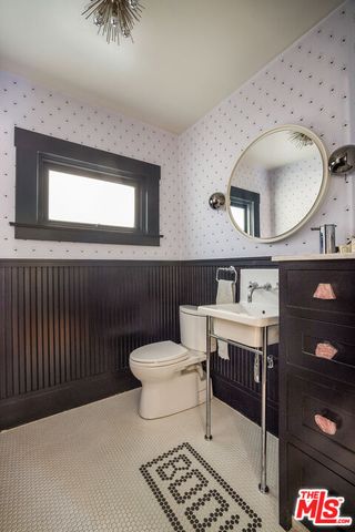 a bathroom with a toilet a sink and mirror