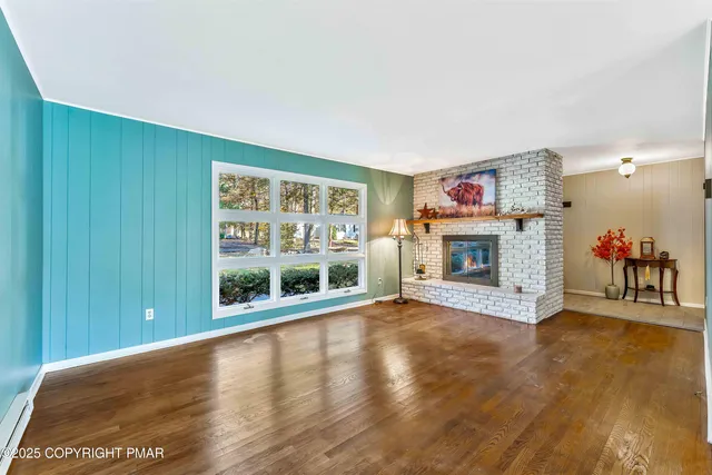 a view of an empty room with a fireplace and a window