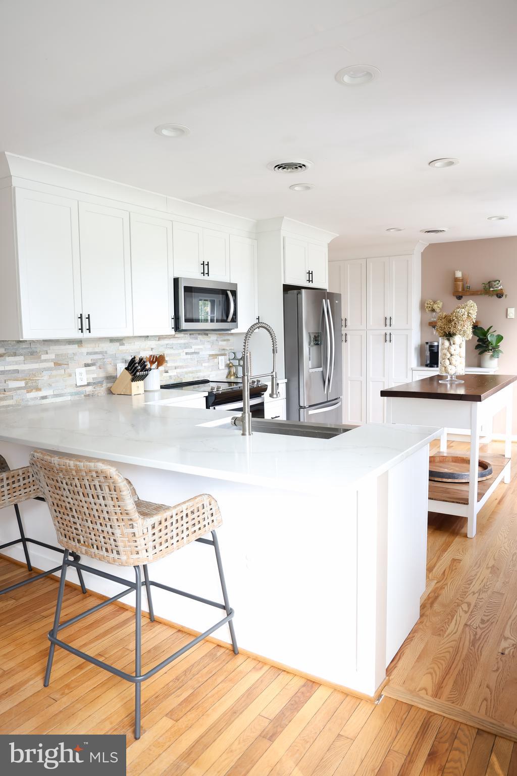 2353 Shuresville Road Darlington, MD 21034 - Photo 6 of 25 a kitchen with stainless steel appliances kitchen island granite countertop a stove a sink a refrigerator and white cabinets with wooden floor