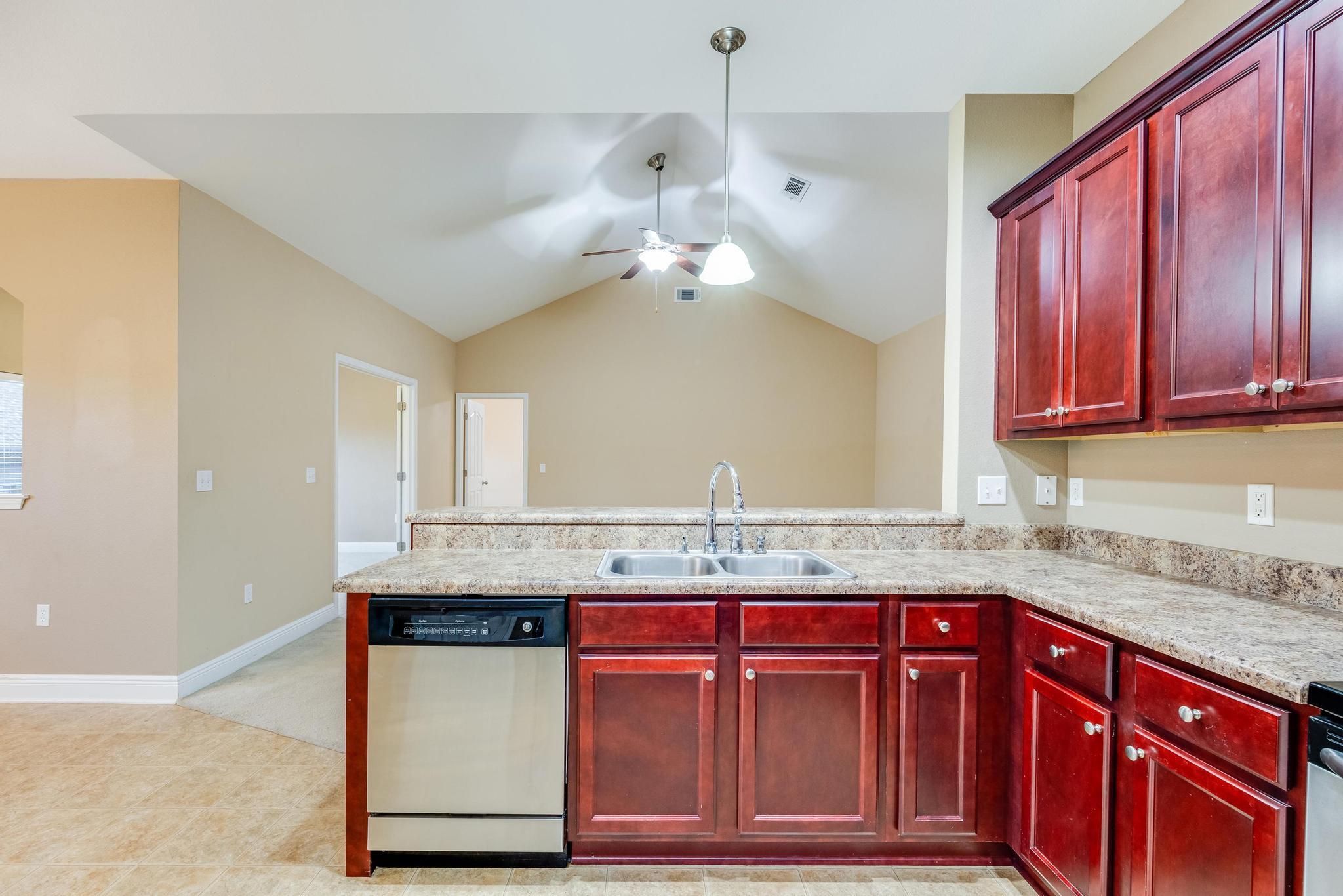 750 Lime Lane Crestview, FL 32536 - Photo 19 of 51 a kitchen with kitchen island granite countertop wooden cabinets a sink and dishwasher