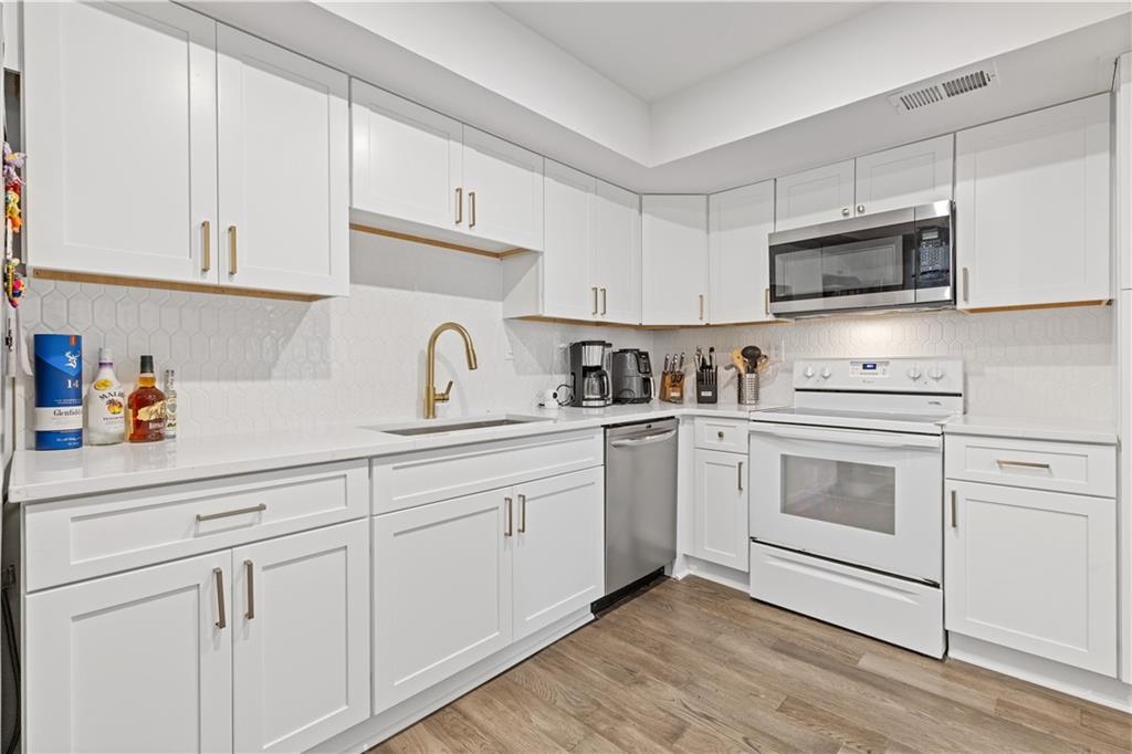 3236 Henderson Mill Road, Unit 1 Chamblee, GA 30341 - Photo 13 of 23 a kitchen with white cabinets stainless steel appliances and sink