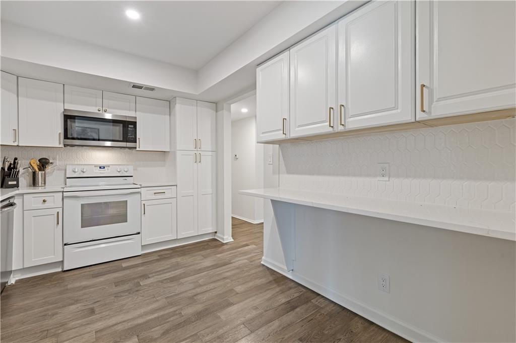 3236 Henderson Mill Road, Unit 1 Chamblee, GA 30341 - Photo 15 of 23 a kitchen with stainless steel appliances a white stove top oven and white cabinets
