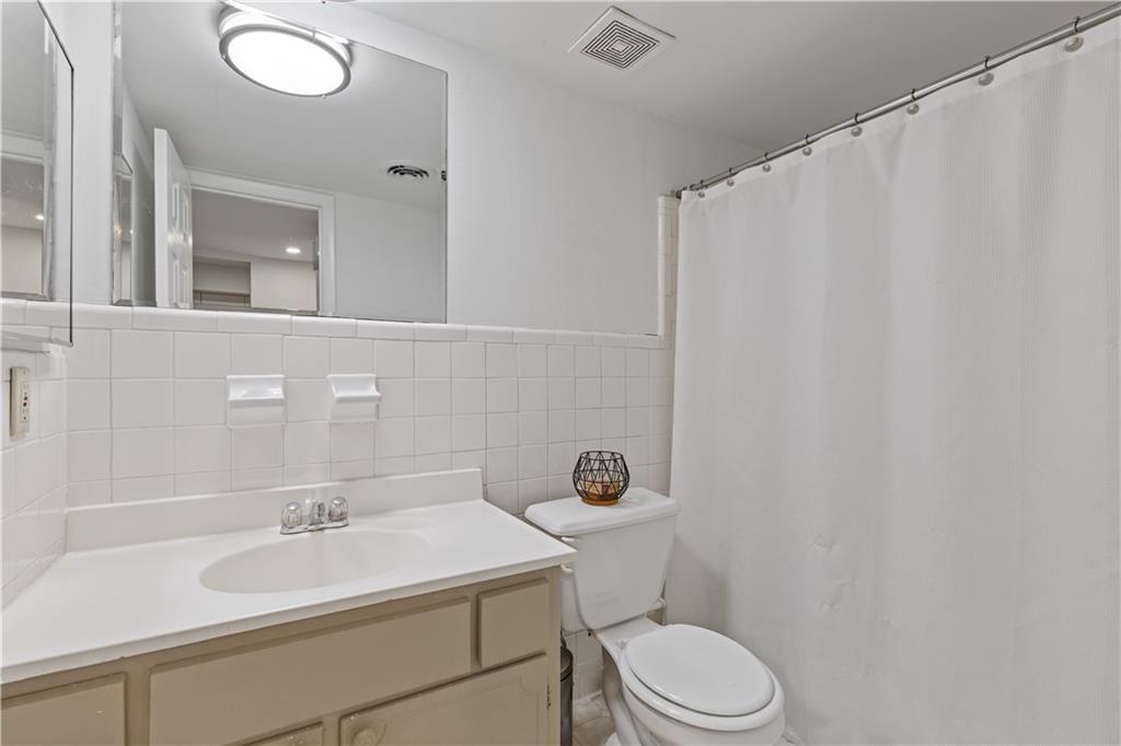 3236 Henderson Mill Road, Unit 1 Chamblee, GA 30341 - Photo 17 of 23 a bathroom with a sink a toilet and mirror