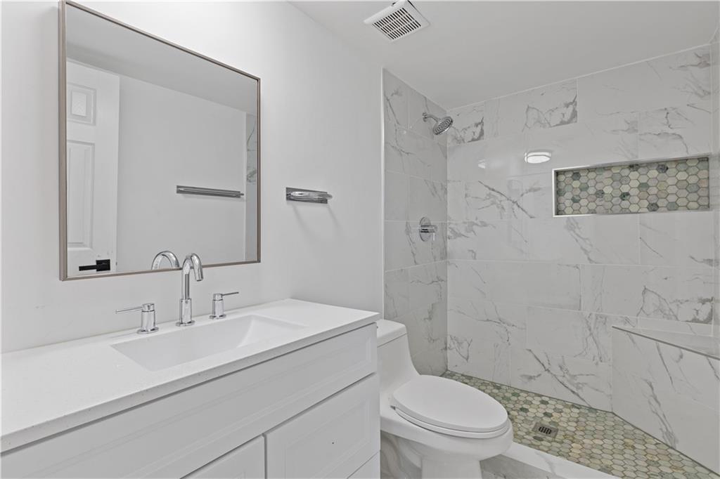 3236 Henderson Mill Road, Unit 1 Chamblee, GA 30341 - Photo 20 of 23 a bathroom with a sink toilet vanity and shower