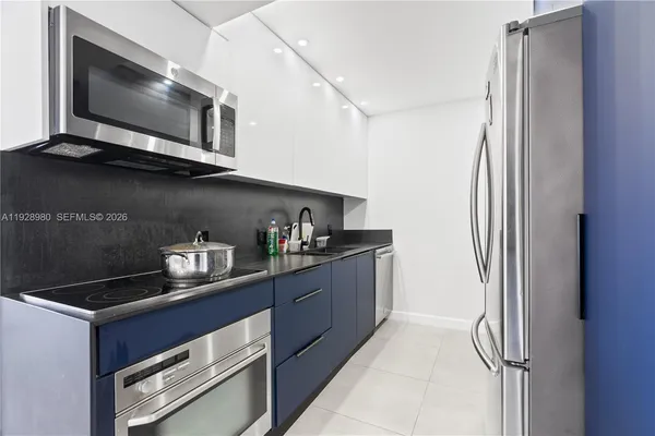 a kitchen with stainless steel appliances granite countertop a refrigerator and a microwave