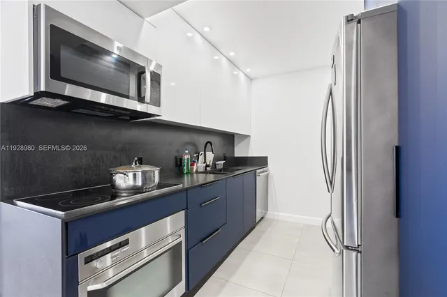 a kitchen with stainless steel appliances granite countertop a refrigerator and a microwave