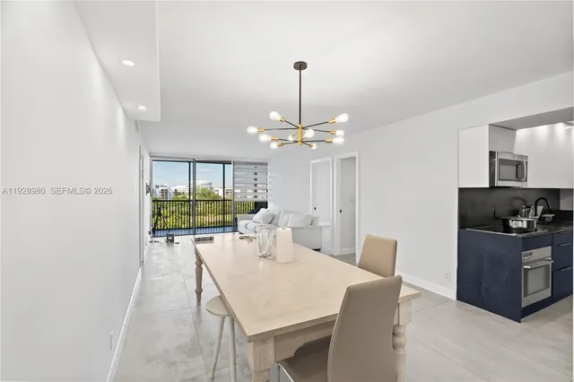 a dining room with furniture a chandelier and window