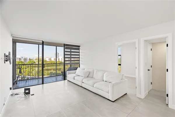 a living room with furniture and a floor to ceiling window