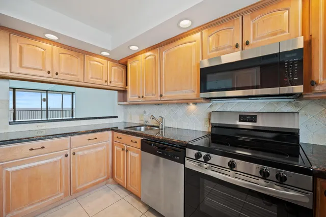 a kitchen with cabinets appliances and a window